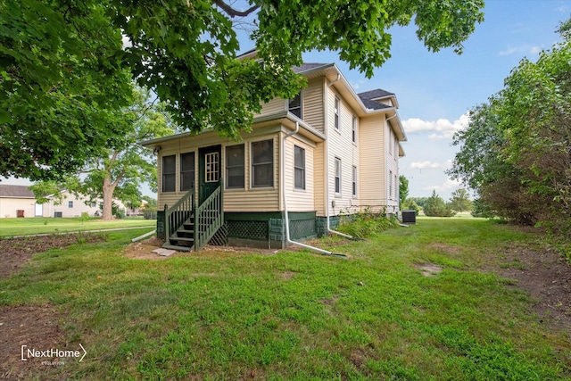 view of front facade with cooling unit, a front lawn, and entry steps