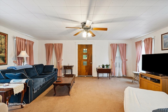 carpeted living area with a ceiling fan