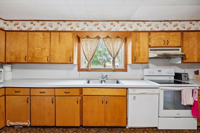 kitchen featuring under cabinet range hood, white appliances, a sink, and light countertops