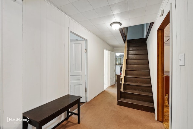 hallway with stairs and light carpet