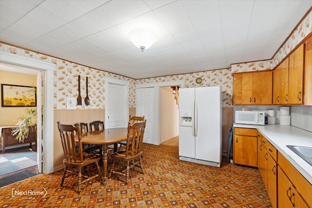 dining area with a wainscoted wall and wallpapered walls