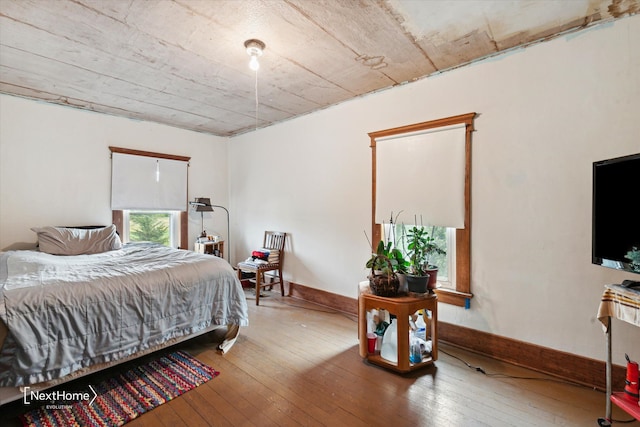 bedroom featuring wood-type flooring and baseboards