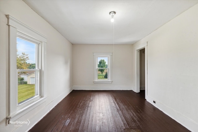 unfurnished room with hardwood / wood-style floors, a wealth of natural light, and baseboards