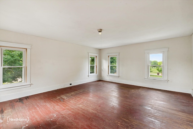 unfurnished room featuring hardwood / wood-style floors and baseboards