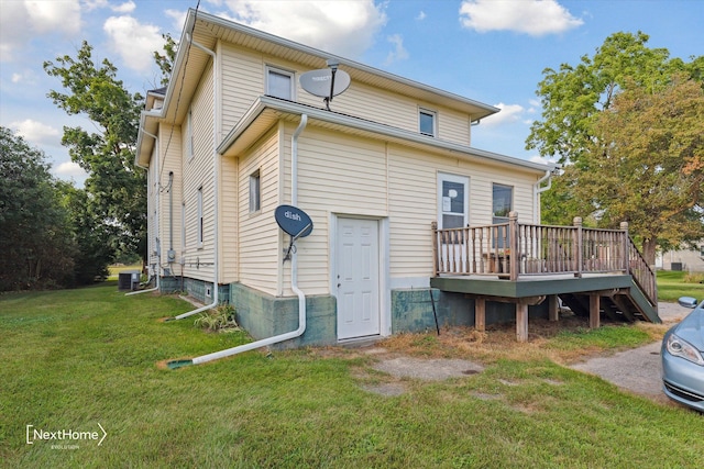 rear view of property with cooling unit, a lawn, and a wooden deck