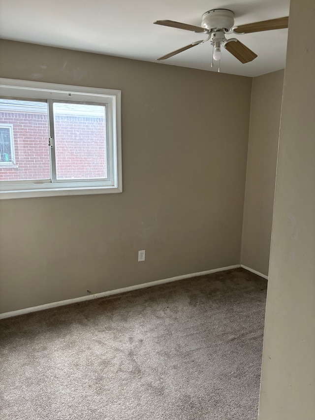 empty room with carpet floors, baseboards, and a ceiling fan