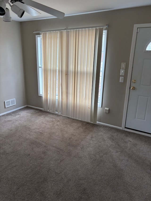 interior space with visible vents, ceiling fan, and baseboards