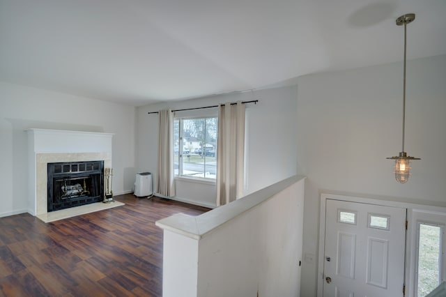 interior space with dark wood-style floors, a fireplace with flush hearth, and baseboards