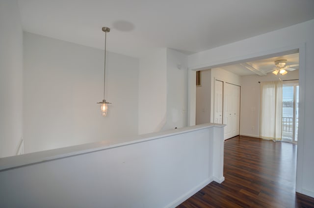 hallway with beam ceiling, dark wood-style flooring, and baseboards