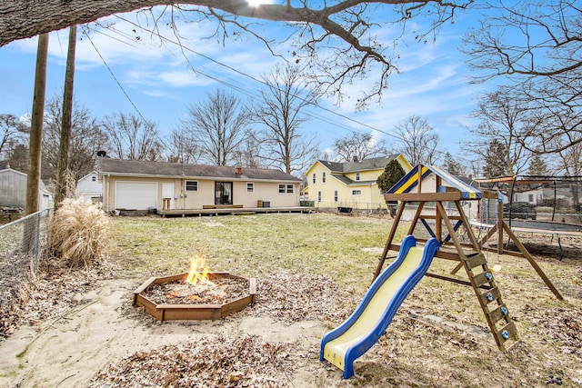 exterior space featuring a fenced backyard, a fire pit, a playground, and a yard