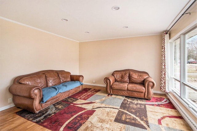 living room with recessed lighting, a baseboard heating unit, wood finished floors, baseboards, and ornamental molding