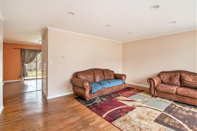 living room featuring crown molding, baseboards, and wood finished floors