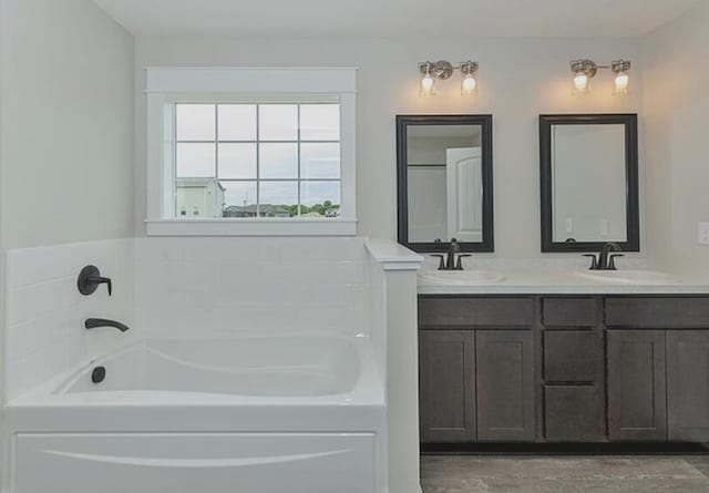 full bathroom featuring double vanity, a sink, and a bath