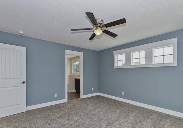 unfurnished bedroom featuring carpet flooring, ceiling fan, a textured ceiling, ensuite bath, and baseboards