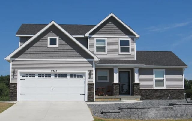 craftsman house featuring stone siding, concrete driveway, and an attached garage