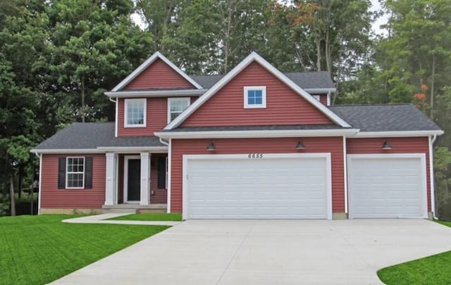 view of front of home with a garage, concrete driveway, and a front lawn