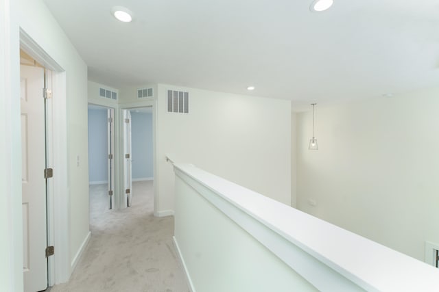 corridor featuring light carpet, recessed lighting, visible vents, and an upstairs landing