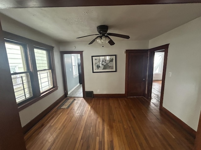 spare room featuring visible vents, baseboards, ceiling fan, and hardwood / wood-style floors