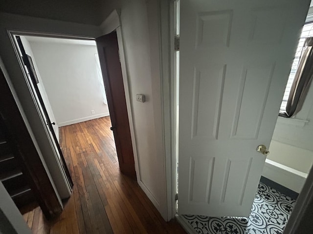 corridor featuring dark wood finished floors and baseboards