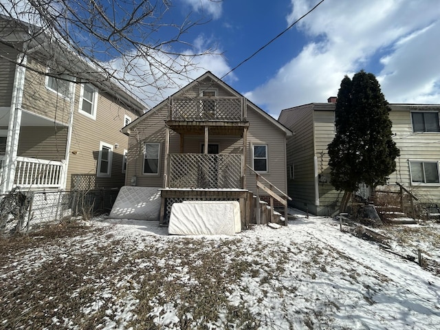 snow covered house featuring a balcony