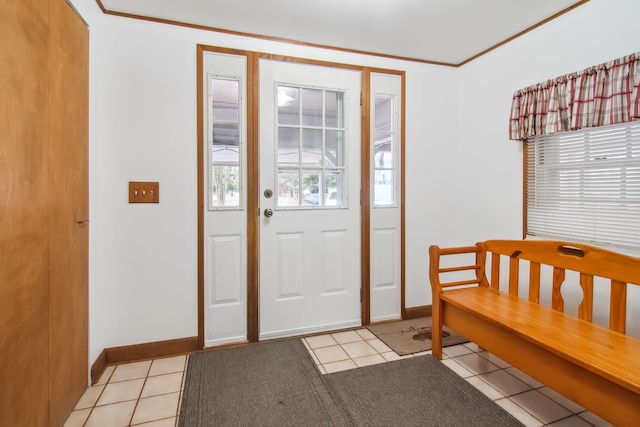 foyer entrance with baseboards, ornamental molding, and light tile patterned flooring