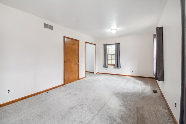 unfurnished room with light carpet, baseboards, and visible vents