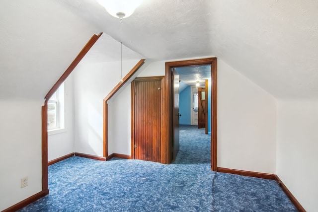 bonus room with carpet floors, baseboards, vaulted ceiling, and a textured ceiling