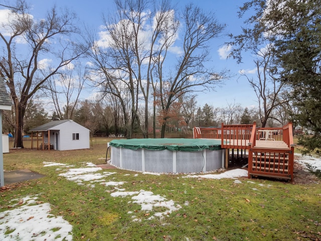 view of yard featuring a deck, an outdoor structure, and a covered pool