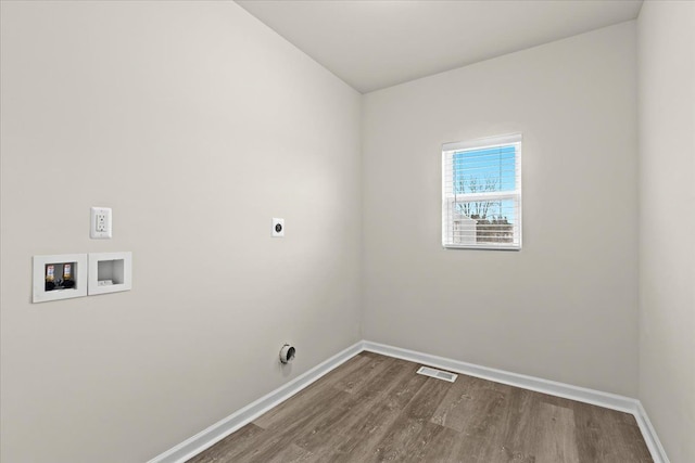 laundry area featuring hookup for an electric dryer, laundry area, visible vents, baseboards, and dark wood-style floors