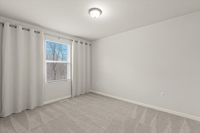 unfurnished room featuring baseboards, visible vents, and light colored carpet