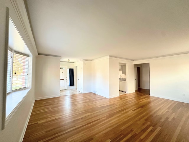 unfurnished room with light wood finished floors, baseboards, and crown molding