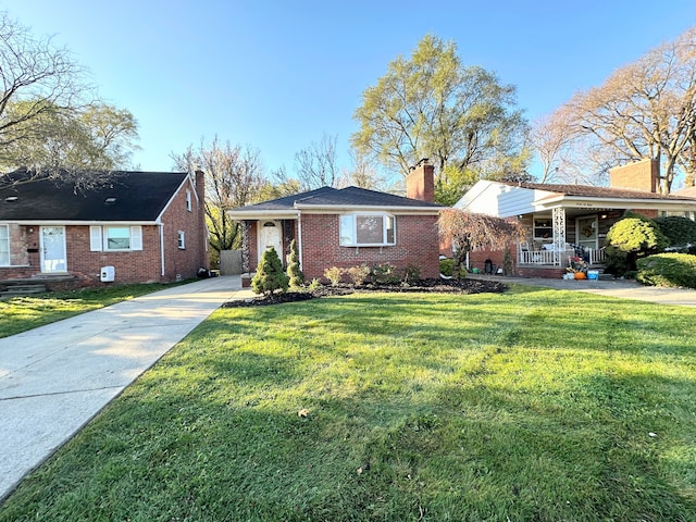 single story home with a porch, brick siding, driveway, a front lawn, and a chimney