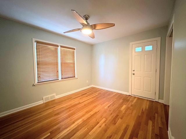 foyer entrance with ceiling fan, wood finished floors, visible vents, and baseboards