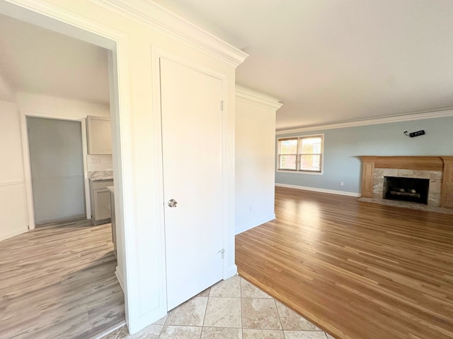 interior space featuring crown molding, light wood-style flooring, and baseboards