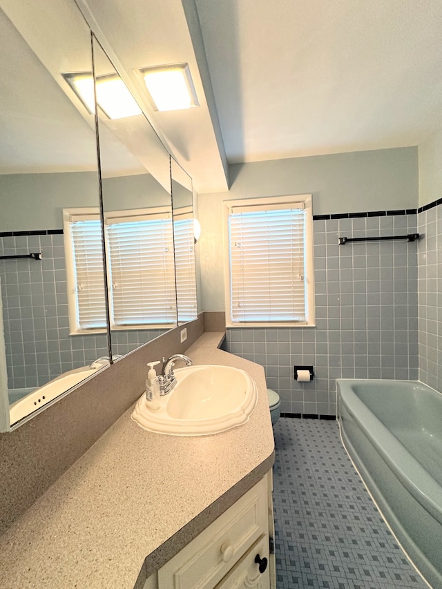 full bath with toilet, a washtub, vanity, tile walls, and a shower