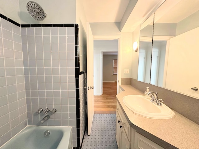 bathroom featuring washtub / shower combination and vanity