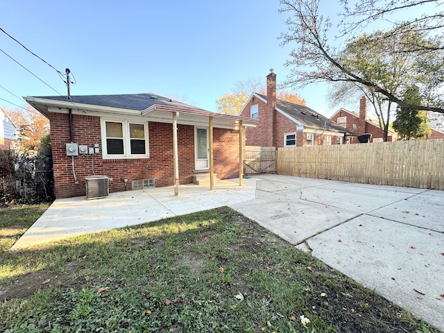 back of house with a fenced backyard, a patio, and brick siding