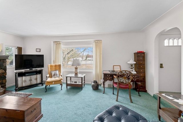 interior space featuring carpet, arched walkways, and baseboards