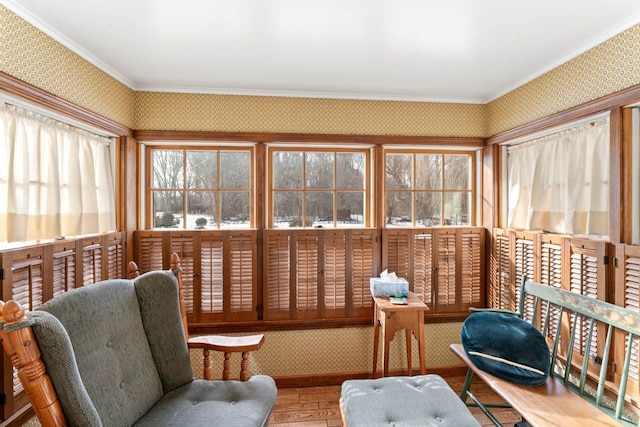 sitting room featuring wallpapered walls, ornamental molding, and wood finished floors