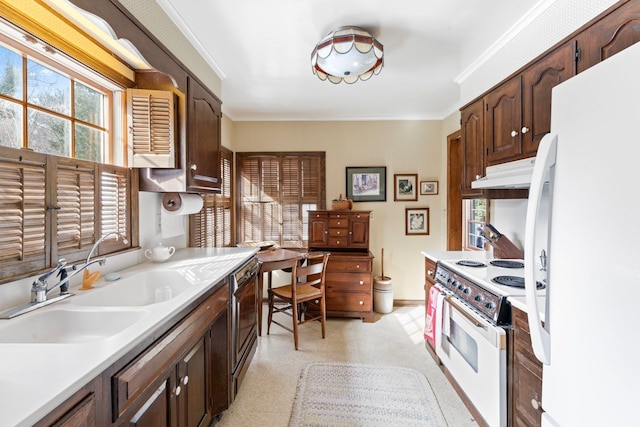 kitchen featuring white appliances, light countertops, and under cabinet range hood