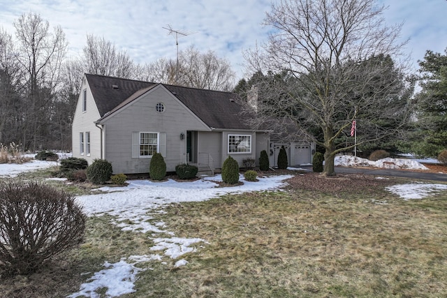 cape cod house featuring a shingled roof and an attached garage