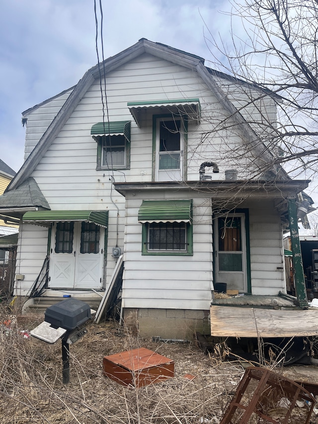 back of house with entry steps and a gambrel roof