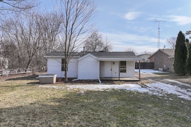 back of property with fence and a yard