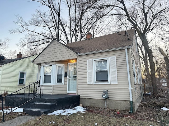 view of front of home featuring a shingled roof and a chimney