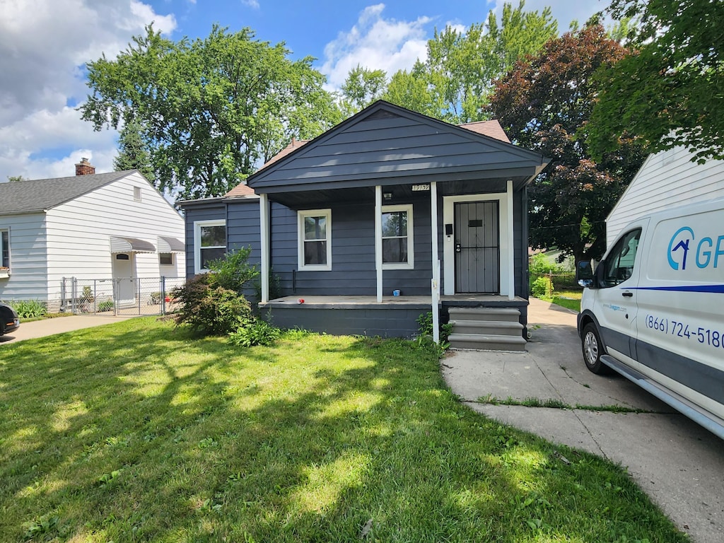 bungalow-style house featuring covered porch and a front yard