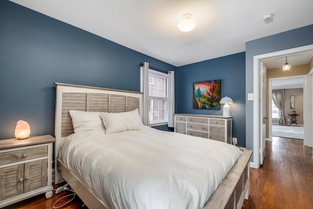 bedroom with baseboards and wood finished floors