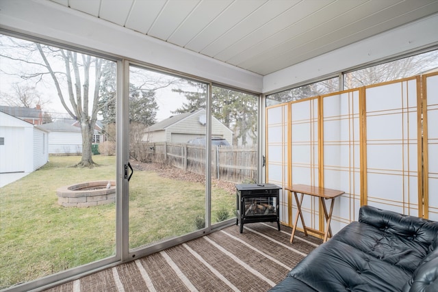 sunroom / solarium with wood ceiling and a wood stove