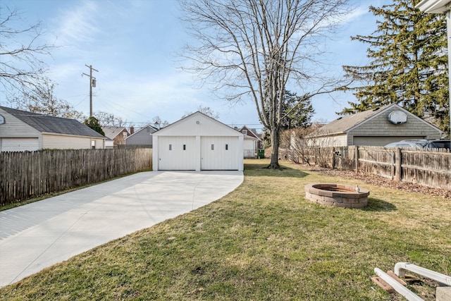 view of yard featuring a fire pit, an outdoor structure, and a fenced backyard