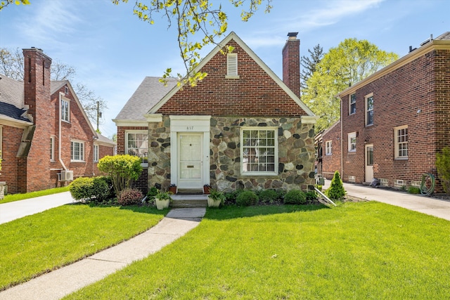 417 Belanger St, Grosse Pointe Farms, MI 48236 - view of front of property with a front lawn, stone siding, and a chimney