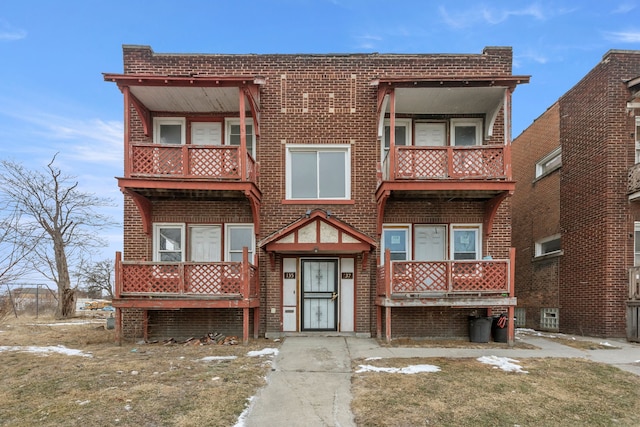 multi unit property featuring covered porch, brick siding, and a balcony